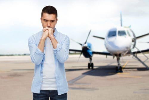 Anxious man about to board plane with travel anxiety - CamJon Travel
